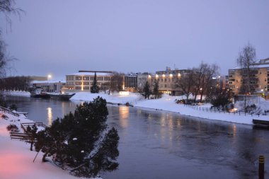 Finlandiya 'nın başkenti Varkaus' un orta kesiminde renkli bir manzara. Olağandışı parlak Finlandiya binaları, yapıları, alışılmadık ağaçları olan evler, göl veya nehir kıyısında bulunan köknar ağaçları..
