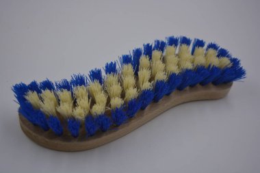 Ev için günlük eşyalar, ev eşyaları beyaz plastik arka planda bulunur. Finlandiya 'da doğal ahşap, beyaz ve mavi tüylerden yapılmış fırça temizleme halıları gibi şeyler..