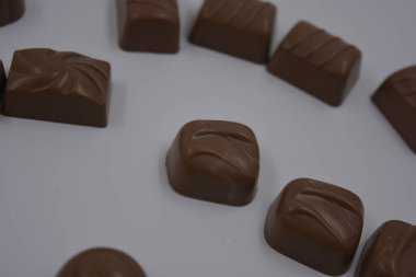 Yiyecek, çok lezzetli süt şekerlemeleri beyaz plastiğin üzerinde bulunur. Çikolatalar yapraklar, cevizler, madalyonlar şeklinde yuvarlak ve kare şeklinde yapılır..