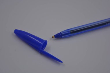 Çalışmalarında, çalışmalarında sürekli kullanılan nesneler. Beyaz plastik zemin üzerinde mürekkep ve koyu mavi kapaklı açık mavi bir plastik kalem bulunur..