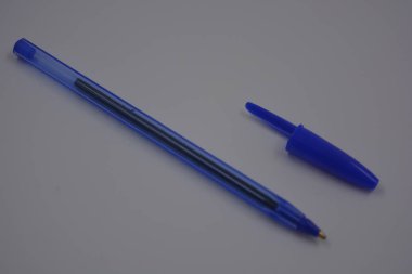 Çalışmalarında, çalışmalarında sürekli kullanılan nesneler. Beyaz plastik zemin üzerinde mürekkep ve koyu mavi kapaklı açık mavi bir plastik kalem bulunur..