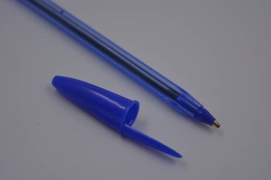 Çalışmalarında, çalışmalarında sürekli kullanılan nesneler. Beyaz plastik zemin üzerinde mürekkep ve koyu mavi kapaklı açık mavi bir plastik kalem bulunur..