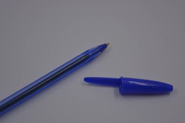 Çalışmalarında, çalışmalarında sürekli kullanılan nesneler. Beyaz plastik zemin üzerinde mürekkep ve koyu mavi kapaklı açık mavi bir plastik kalem bulunur..