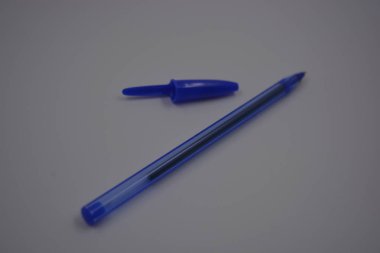 Çalışmalarında, çalışmalarında sürekli kullanılan nesneler. Beyaz plastik zemin üzerinde mürekkep ve koyu mavi kapaklı açık mavi bir plastik kalem bulunur..