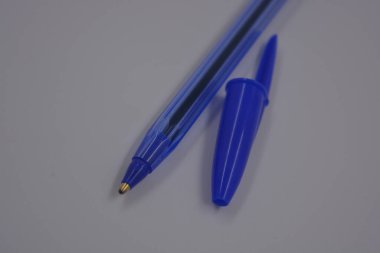Çalışmalarında, çalışmalarında sürekli kullanılan nesneler. Beyaz plastik zemin üzerinde mürekkep ve koyu mavi kapaklı açık mavi bir plastik kalem bulunur..