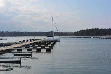 Bahar havası, büyük körfez, göl, temiz suyla körfez. Şık ahşap iskeleleri ve tekne parkı olan güzel bir sahil doğası. Sürat tekneleri, modern yelkenler ve beyaz yatlar Finlandiya 'nın Espoo limanına demirlemiştir..