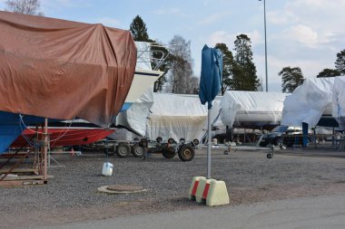 Bahar havası, körfeze yakın güzel bir doğa. Finlandiya 'nın Espoo adasında büyük bir tekne parkı bulunmaktadır. Birçok büyük tekne, motorlu tekne, yelkenli ve yat muşamba örtüsünün altında..
