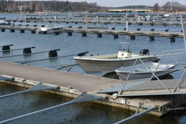 Bahar havası, büyük körfez, göl, temiz suyla körfez. Şık ahşap iskeleleri ve tekne parkı olan güzel bir sahil doğası. Sürat tekneleri, modern yelkenler ve beyaz yatlar Finlandiya 'nın Espoo limanına demirlemiştir..