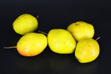 Sağlıklı yiyecekler, taze meyveler, sağlık. Siyah bir arka planda parlak kırmızı yeşil armutlar bulunur..