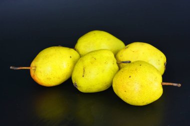 Sağlıklı yiyecekler, taze meyveler, sağlık. Siyah bir arka planda parlak kırmızı yeşil armutlar bulunur..