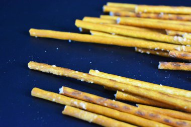 Fast food, gıda ürünleri. Polietilen ambalajda paketlenmiş ve siyah plastik arka planda bulunan uzun buğday kamışları.