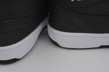 Güzel, genç spor ayakkabıları, beyaz sert tabanlı siyah çizmeler beyaz plastiğin üzerinde.. İzolasyonlu, sentetik kürklü, güzel pamuklu siyah bağcıklı deri botlar..