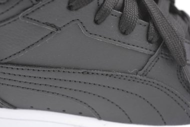 Güzel, genç spor ayakkabıları, beyaz sert tabanlı siyah çizmeler beyaz plastiğin üzerinde.. İzolasyonlu, sentetik kürklü, güzel pamuklu siyah bağcıklı deri botlar..