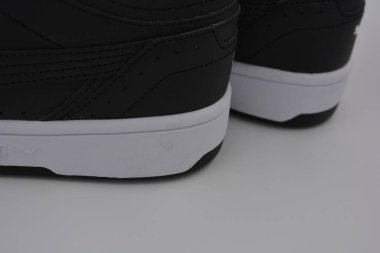 Güzel, genç spor ayakkabıları, beyaz sert tabanlı siyah çizmeler beyaz plastiğin üzerinde.. İzolasyonlu, sentetik kürklü, güzel pamuklu siyah bağcıklı deri botlar..