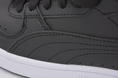 Güzel, genç spor ayakkabıları, beyaz sert tabanlı siyah çizmeler beyaz plastiğin üzerinde.. İzolasyonlu, sentetik kürklü, güzel pamuklu siyah bağcıklı deri botlar..