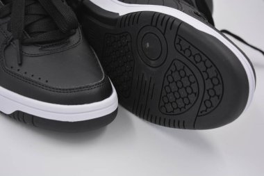 Eşyalar, deri giysiler, ayakkabılar, siyah botlar. Kendi yapısı ve dokusuna sahip kalın kauçuktan yapılmış beyaz ayakkabılı siyah taban. Ayakkabı, taban beyaz plastik arka planda yer almaktadır..