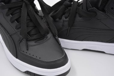 Güzel, genç spor ayakkabıları, beyaz sert tabanlı siyah çizmeler beyaz plastiğin üzerinde.. İzolasyonlu, sentetik kürklü, güzel pamuklu siyah bağcıklı deri botlar..