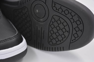 Eşyalar, deri giysiler, ayakkabılar, siyah botlar. Kendi yapısı ve dokusuna sahip kalın kauçuktan yapılmış beyaz ayakkabılı siyah taban. Ayakkabı, taban beyaz plastik arka planda yer almaktadır..