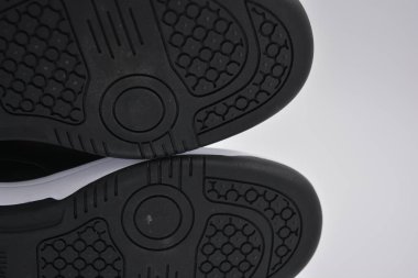 Eşyalar, deri giysiler, ayakkabılar, siyah botlar. Kendi yapısı ve dokusuna sahip kalın kauçuktan yapılmış beyaz ayakkabılı siyah taban. Ayakkabı, taban beyaz plastik arka planda yer almaktadır..