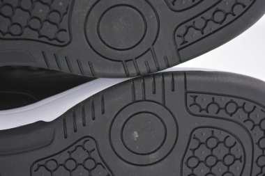 Eşyalar, deri giysiler, ayakkabılar, siyah botlar. Kendi yapısı ve dokusuna sahip kalın kauçuktan yapılmış beyaz ayakkabılı siyah taban. Ayakkabı, taban beyaz plastik arka planda yer almaktadır..