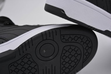 Eşyalar, deri giysiler, ayakkabılar, siyah botlar. Kendi yapısı ve dokusuna sahip kalın kauçuktan yapılmış beyaz ayakkabılı siyah taban. Ayakkabı, taban beyaz plastik arka planda yer almaktadır..