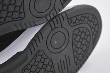 Eşyalar, deri giysiler, ayakkabılar, siyah botlar. Kendi yapısı ve dokusuna sahip kalın kauçuktan yapılmış beyaz ayakkabılı siyah taban. Ayakkabı, taban beyaz plastik arka planda yer almaktadır..