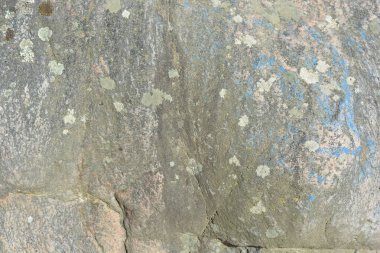 Alışılmadık doğal arka planlar, güneşin altındaki doğal doğa. Doğal kahverengi-gri taşların arka planı, ilginç desenli ve desenli büyük granit..