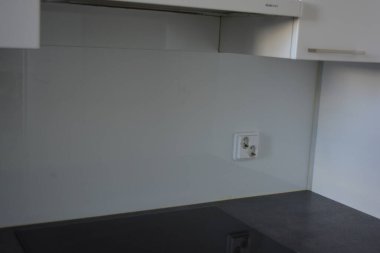 Mutfak gereçleri, gri mutfak tezgahı, beyaz dolaplar, beyaz Avrupa tıkaçlı gri elektrikli fırın olan tipik bir Finlandiya mutfağı..