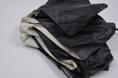Yeni, güzel bej, altın, beyaz, siyah saplı, açık renk şemsiye, su ve yağmurdan siyah astarlı beyaz plastik arka planda yer almaktadır..
