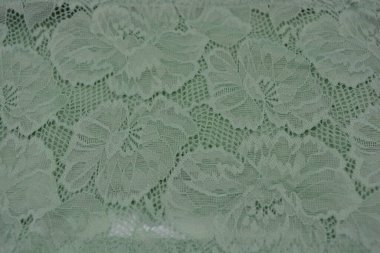 Çiçek tomurcuklarından, çiçek açan güllerden, şakayıklardan yeşil zeytin güzel dantel. Alışılmadık bir kumaş, doğal pamuktan yapılmış açık yeşil kumaşa işlenmiş parıltılı dantel..