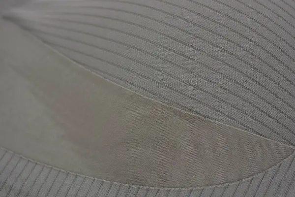 Malzemeler, açık yeşil, kahverengi ince kumaş, doku ve yapı, küçük çizgiler. Sentetik liflerden yapılmış alışılmadık bir kumaş çeliği ve beyaz plastik bir arka planda yer alıyor..
