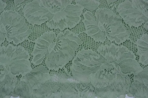 Çiçek tomurcuklarından, çiçek açan güllerden, şakayıklardan yeşil zeytin güzel dantel. Alışılmadık bir kumaş, doğal pamuktan yapılmış açık yeşil kumaşa işlenmiş parıltılı dantel..