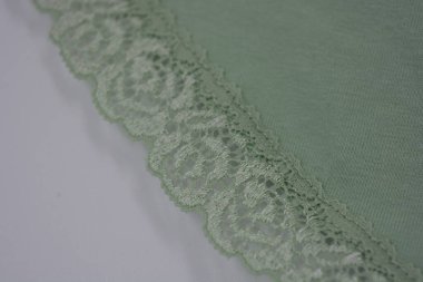 Çiçek tomurcuklarından, çiçek açan güllerden, şakayıklardan yeşil zeytin güzel dantel. Alışılmadık bir kumaş, doğal pamuktan yapılmış açık yeşil kumaşa işlenmiş parıltılı dantel..