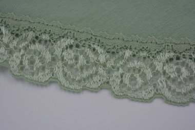 Çiçek tomurcuklarından, çiçek açan güllerden, şakayıklardan yeşil zeytin güzel dantel. Alışılmadık bir kumaş, doğal pamuktan yapılmış açık yeşil kumaşa işlenmiş parıltılı dantel..