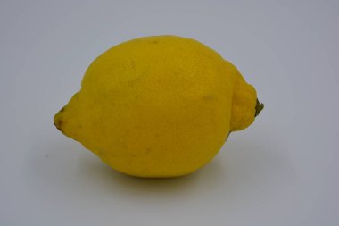 Ürünler, sağlıklı ve sağlıklı yiyecekler, taze meyveler. Olgun sulu sarı limon beyaz plastik arka planda yer alır..