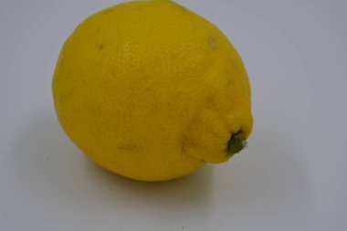 Ürünler, sağlıklı ve sağlıklı yiyecekler, taze meyveler. Olgun sulu sarı limon beyaz plastik arka planda yer alır..