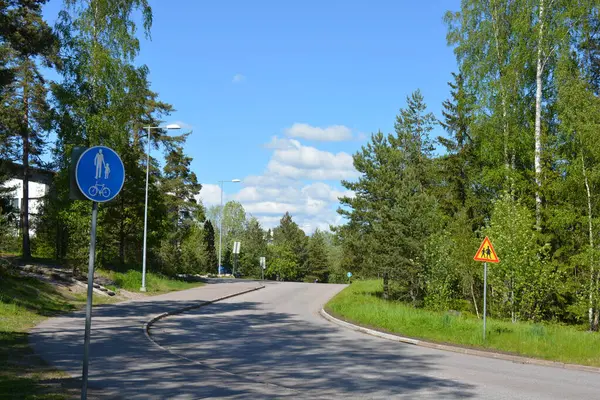 Finlandiya 'nın Espoo şehrinde güzel caddeler, otoyollar, yollar ve rotalar manzarası vardır. Girişleri olan güzel özel evler, yeşil çimenler, çalılar, yeşil yapraklı ağaçlar, kaldırım boyunca büyüyen ince köknarlar, yollar..
