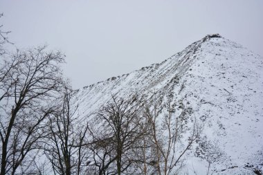 Parlak, güzel doğa, kışın dondurucu hava. Büyük tepeler, yoğun beyaz karla kaplı keskin dağlar. Yüksek tepe, yüksek dağ ve ağaçların yanından geçen dolambaçlı bir yol..