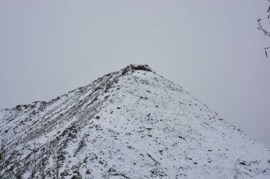 Parlak, güzel doğa, kışın dondurucu hava. Büyük tepeler, yoğun beyaz karla kaplı keskin dağlar. Yüksek tepe, yüksek dağ ve ağaçların yanından geçen dolambaçlı bir yol..