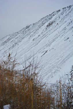 Parlak, güzel doğa, kışın dondurucu hava. Büyük tepeler, yoğun beyaz karla kaplı keskin dağlar. Yüksek tepe, yüksek dağ ve ağaçların yanından geçen dolambaçlı bir yol..