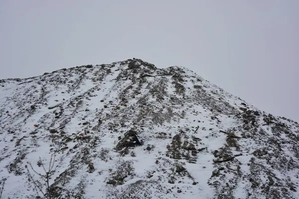 Parlak, güzel doğa, kışın dondurucu hava. Büyük tepeler, yoğun beyaz karla kaplı keskin dağlar. Yüksek tepe, yüksek dağ ve ağaçların yanından geçen dolambaçlı bir yol..