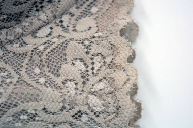 Güzel, zarif, kahverengi dantel kumaş. Çiçekler ve desenler beyaz arka planda..