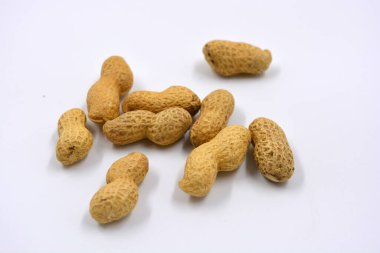 Kahverengi kabuklarındaki doğal fıstıklar beyaz arka planda yer alır..