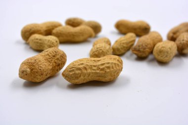 Kahverengi kabuklarındaki doğal fıstıklar beyaz arka planda yer alır..