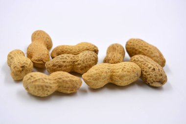 Kahverengi kabuklarındaki doğal fıstıklar beyaz arka planda yer alır..