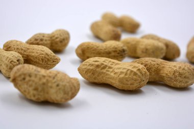 Kahverengi kabuklarındaki doğal fıstıklar beyaz arka planda yer alır..