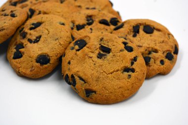 Beyaz arka planda çikolata parçalı büyük, lezzetli bir kurabiye..