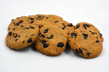 Beyaz arka planda çikolata parçalı büyük, lezzetli bir kurabiye..