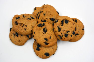 Beyaz arka planda çikolata parçalı büyük, lezzetli bir kurabiye..