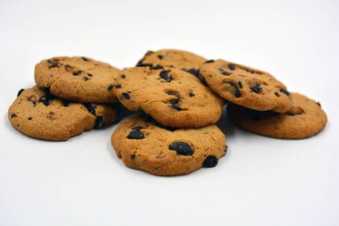 Beyaz arka planda çikolata parçalı büyük, lezzetli bir kurabiye..